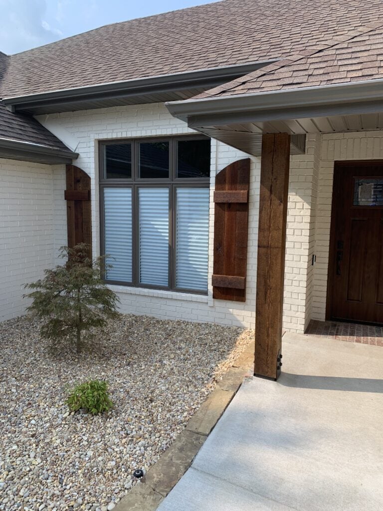 Beautiful Craftsman-style house with white brick, wooden accents, and large windows.