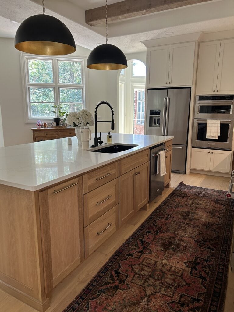 Detail of the kitchen island focusing on the sink area, integrated dishwasher, and countertop accessories.